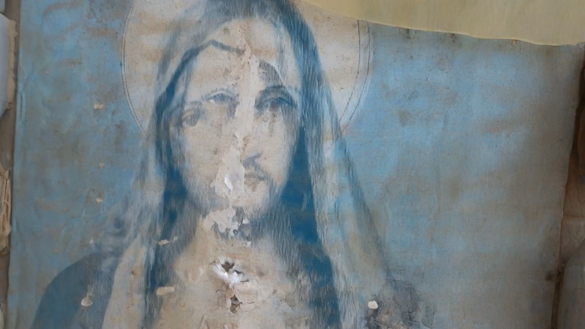 A face emerging from a layered, weathered image