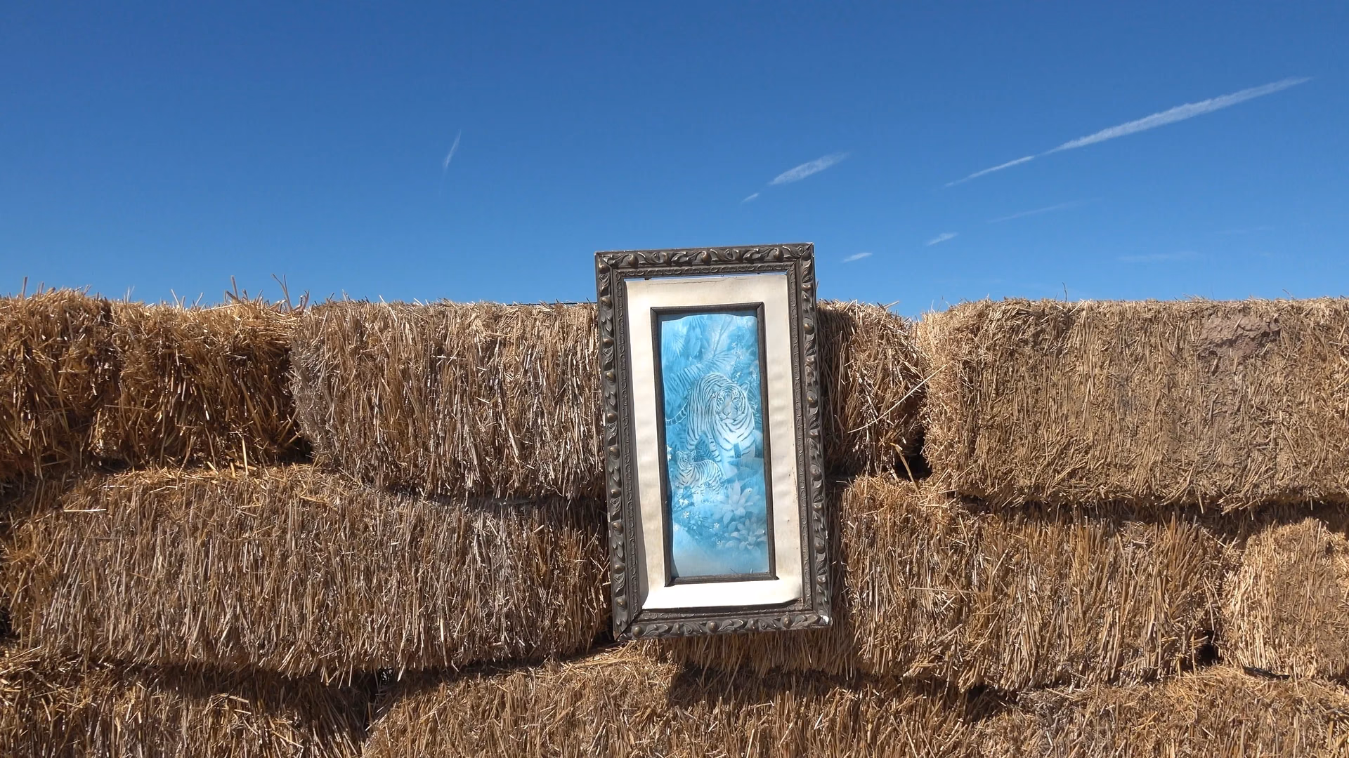 A television set resting against hay bales