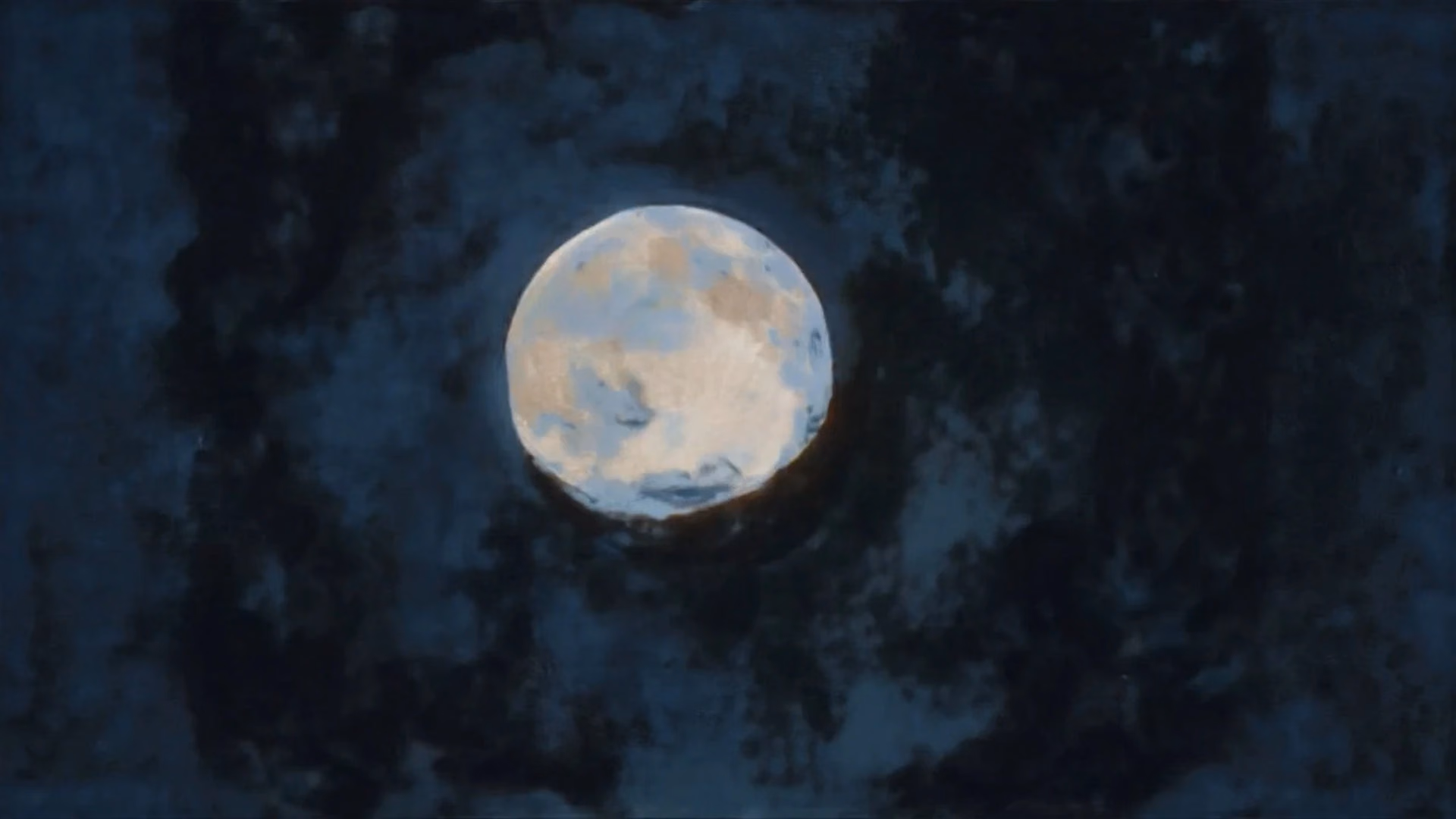 A luminous moon within a dark, cloudy sky