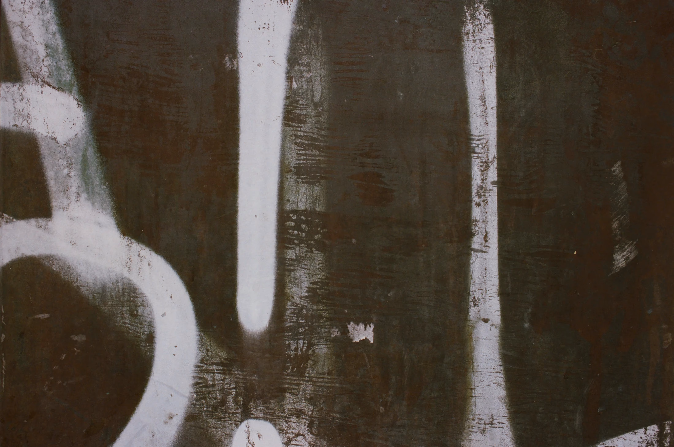 White painted gestures on a dark, worn wall