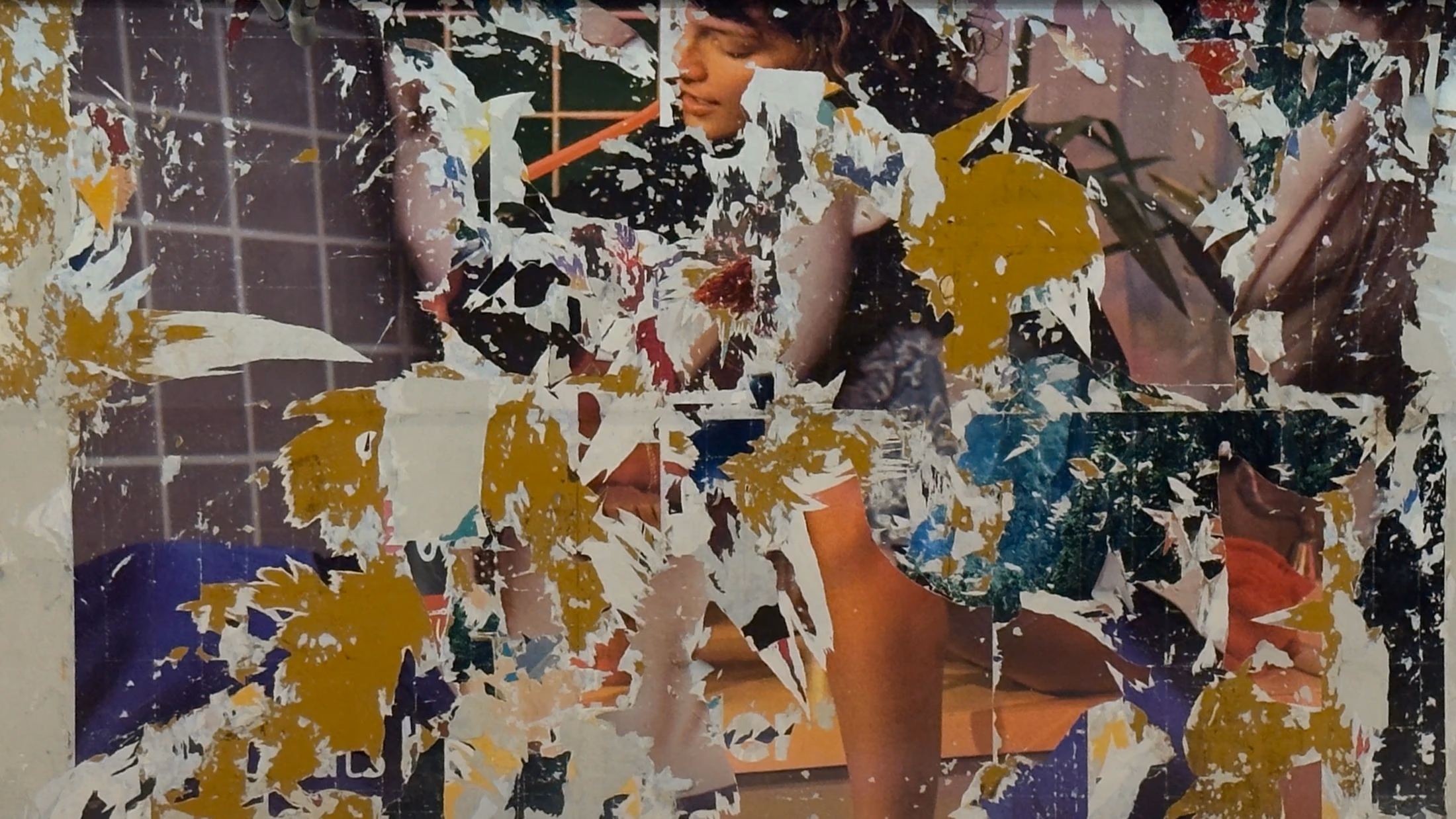 Fragments of colourful posters layered on a wall